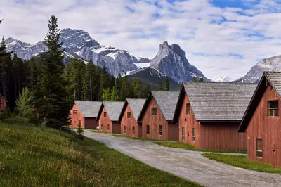 a row of red barns in front of mountains at Banff Gate Mountain Resort in Canmore