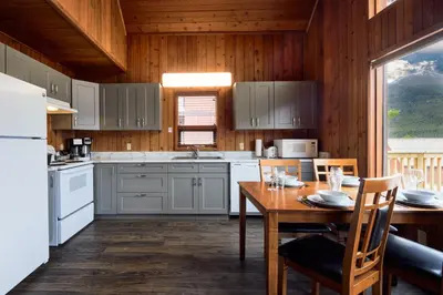 a kitchen with white appliances and a table with chairs at Banff Gate Mountain Resort in Canmore