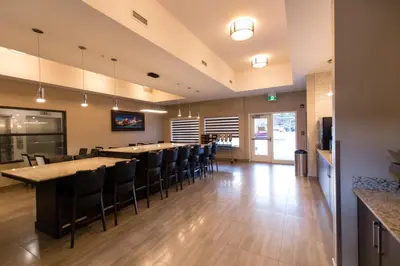 a restaurant with a long bar with black chairs at Super 8 by Wyndham Canmore in Canmore
