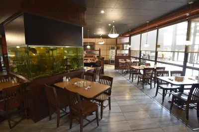 a restaurant with tables and chairs and a fish tank at Tropical Inn - North Battleford in North Battleford