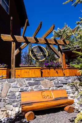 a wooden bench sitting in front of a building at A Bear and Bison Country Inn in Canmore