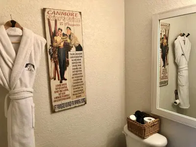 a bathroom with a poster on the wall and a toilet at A Bear and Bison Country Inn in Canmore