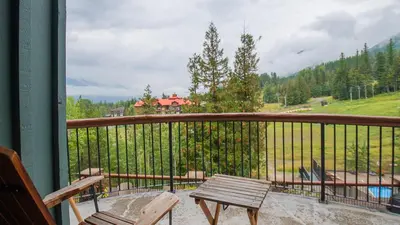 a balcony with a bench and a view of a mountain at Snow Creek Lodge by Fernie Lodging Co in Fernie