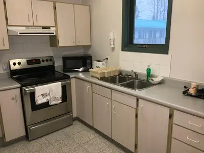 a kitchen with a sink and a stove at Alpine Inn in Valemount