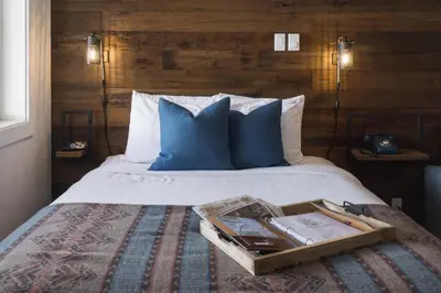 a hotel room with a bed with a tray on it at Snow Valley Lodging in Fernie