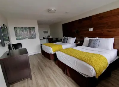 a hotel room with two beds and a television at Snow Valley Lodging in Fernie