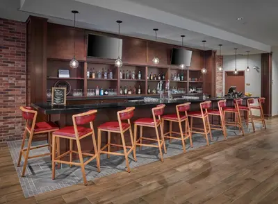 a bar with red bar stools in a room at Element Edmonton West in Edmonton
