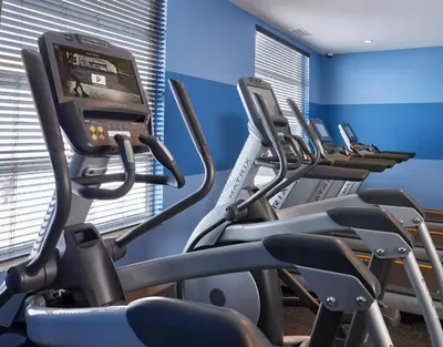 a gym with rows of cardio machines in a row at Element Edmonton West in Edmonton