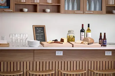 a counter with bottles of wine and bread and wine glasses at Element Edmonton West in Edmonton