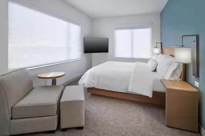 a bedroom with a bed and a couch and a tv at Element Edmonton West in Edmonton