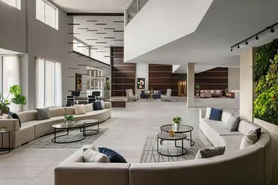 a lobby with couches and tables in a building at The Westin Calgary Airport in Calgary