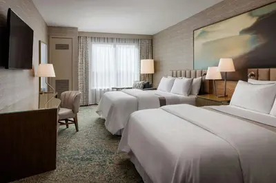 a hotel room with two beds and a television at The Westin Calgary Airport in Calgary