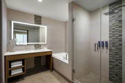 a bathroom with a shower and a sink and a mirror at The Westin Calgary Airport in Calgary