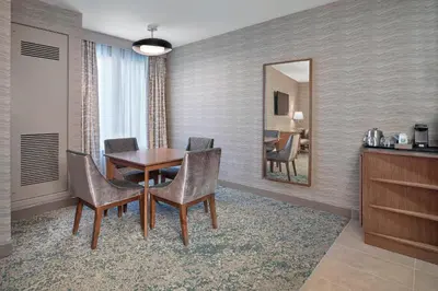 a dining room with a table and chairs and a mirror at The Westin Calgary Airport in Calgary