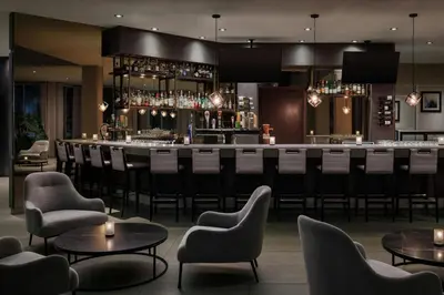 a bar in a hotel with chairs and tables at The Westin Calgary Airport in Calgary