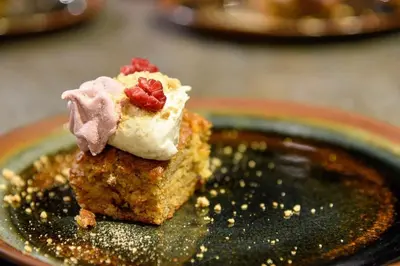 a piece of cake with whipped cream and strawberries on a plate at Inn on the Lake - Whitehorse in Marsh Lake