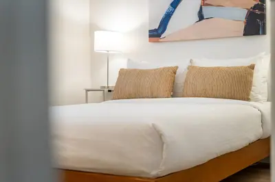 a bed with white sheets and pillows in a room at Okanagan Lakefront Resort in Penticton