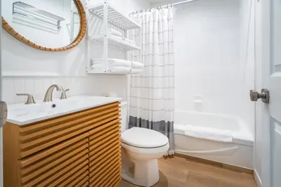 a bathroom with a toilet and a sink and a mirror at Okanagan Lakefront Resort in Penticton
