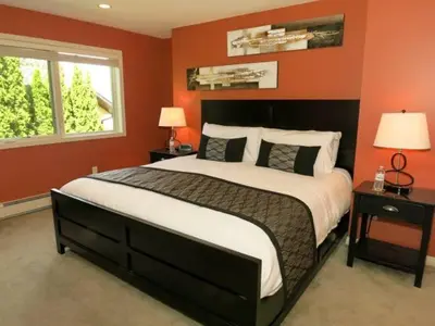 a bedroom with a large bed with red walls at A View of the Lake B & B in West Kelowna