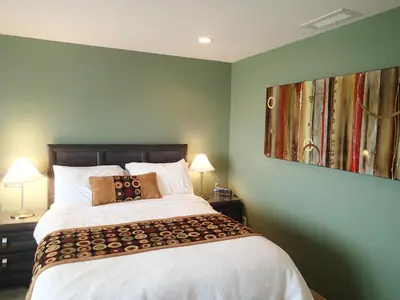 a bedroom with a large bed with green walls at A View of the Lake B & B in West Kelowna