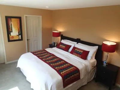 a bedroom with a large white bed with red pillows at A View of the Lake B & B in West Kelowna
