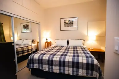 a small bedroom with a bed and a mirror at Alpenrose Revelstoke Bed & Breakfast in Revelstoke