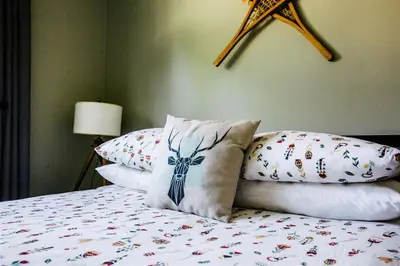 a bedroom with a bed with pillows and a star on the wall at Alpenrose Revelstoke Bed & Breakfast in Revelstoke