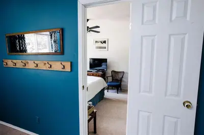 a bedroom with a blue accent wall and a bed at Alpenrose Revelstoke Bed & Breakfast in Revelstoke