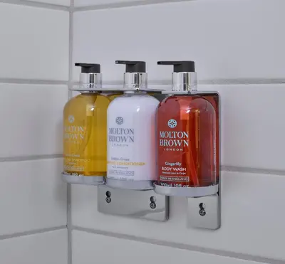 three bottles of shampoo and conditioner on a wall at Matrix Hotel in Edmonton