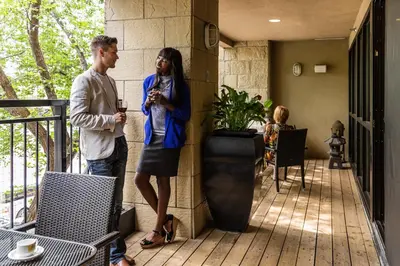 a man and a woman standing on a porch at Metterra Hotel on Whyte in Edmonton