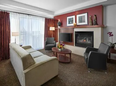 a living room with a couch and a fireplace at Metterra Hotel on Whyte in Edmonton