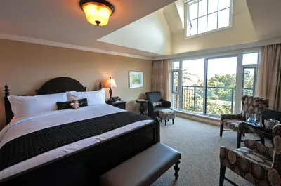 a hotel room with a bed and a large window at Oak Bay Beach Hotel in Victoria