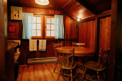 a kitchen with a table and chairs in a room at Addison's Bungalows in Brisco