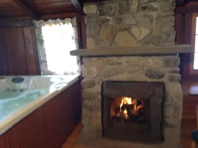 a fireplace in a kitchen with a bath tub and a fireplace at Addison's Bungalows in Brisco