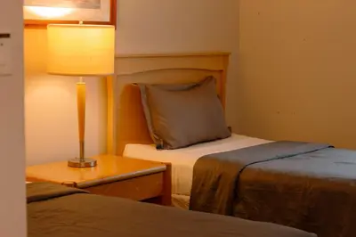 a hotel room with two beds and a lamp at Carey Centre on UBC campus in Vancouver