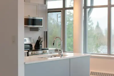 a white kitchen with a sink and a window at Carey Centre on UBC campus in Vancouver