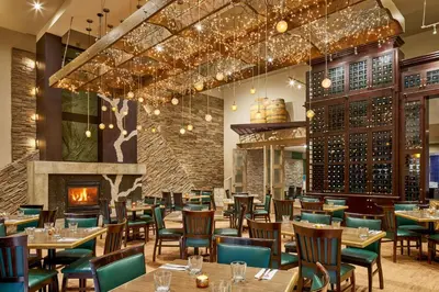 a restaurant with tables and chairs and a fireplace at Varscona Hotel on Whyte in Edmonton