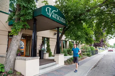 a man walking down a sidewalk in front of a restaurant at Varscona Hotel on Whyte in Edmonton