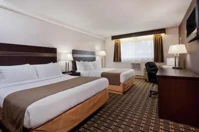 a hotel room with two beds and a desk at Super 8 by Wyndham Valemount in Valemount
