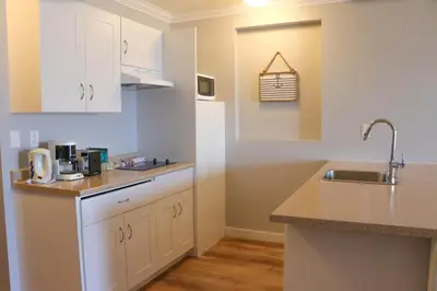 a kitchen with white cabinets and a sink at The Waterfront Suites and Marina in Nanaimo