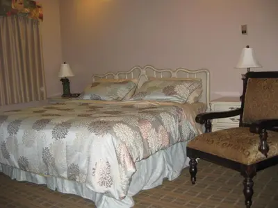 a bedroom with a bed and a chair and a chair at King's Motel & Restaurant in St. Paul