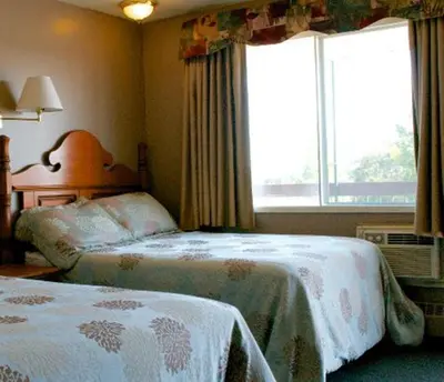 a bedroom with two beds and a window at King's Motel & Restaurant in St. Paul