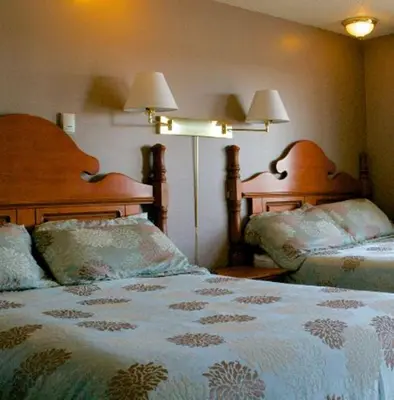 a bedroom with two beds and two lamps at King's Motel & Restaurant in St. Paul