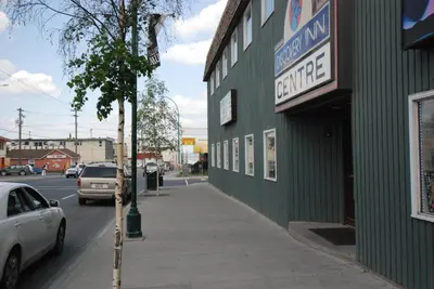 a green building with a sign on the side of a street at Discovery Inn in Yellowknife