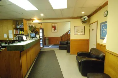 a waiting area of a waiting room with chairs and a counter at Discovery Inn in Yellowknife
