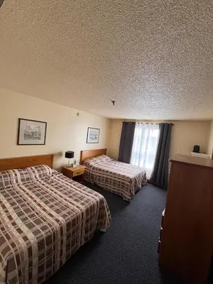 a hotel room with two beds and a window at Discovery Inn in Yellowknife