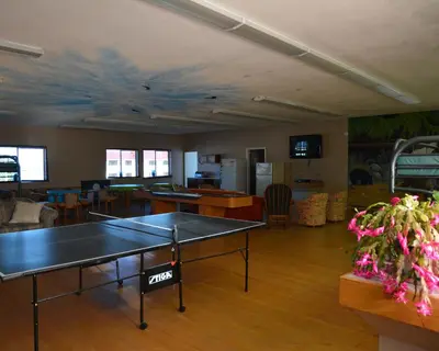 a living room with a ping pong table in it at North Coast Trail Backpackers Ltd in Port Hardy