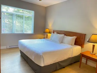 a bedroom with a bed with two lamps and a window at Crown Isle Resort & Golf Community in Courtenay