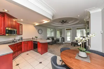 a kitchen and living room with red cabinets and a table at Crown Isle Resort & Golf Community in Courtenay