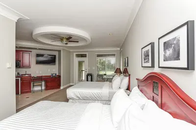 a bedroom with two beds and a kitchen at Crown Isle Resort & Golf Community in Courtenay
